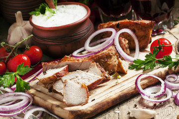 Pieces of meat barbecue on a wooden cutting board with vegetable