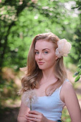 Fototapeta premium Beautiful girl with a dandelion in the hand