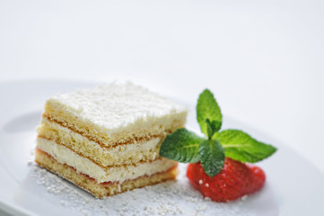 vanilla cream cake with sugar powder, strawberry and mint leaf on white plate, sweet dessert or breakfast, patisserie, photography for shop