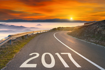 Empty mountain road to upcoming 2017 at sunset