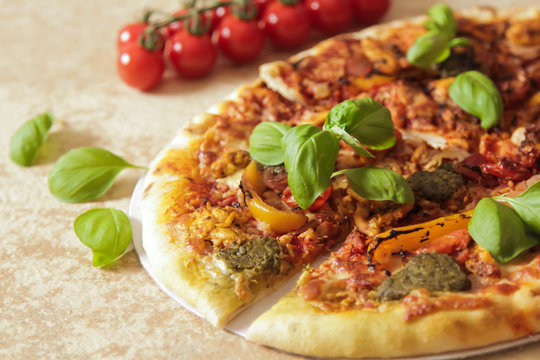 Sliced Italian pizza with basil and yellow pepper