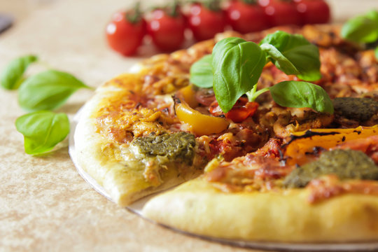 Sliced Italian pizza with basil and yellow pepper
