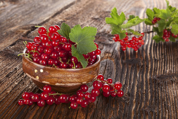 Red currant on wooden background.