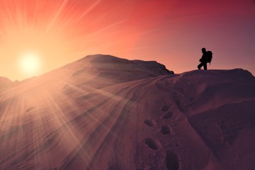 A man in mountain sunset winter
