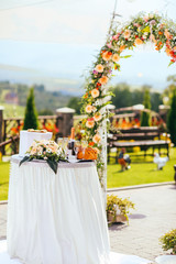 wedding ceremony arch with roses in the summer day