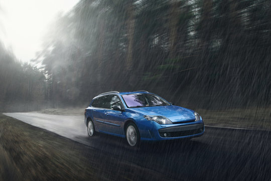 Blue car fast drive on wet road in rain at daytime