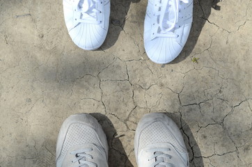 Two Pairs of Shoes in Opposite Side on Dry Dirt