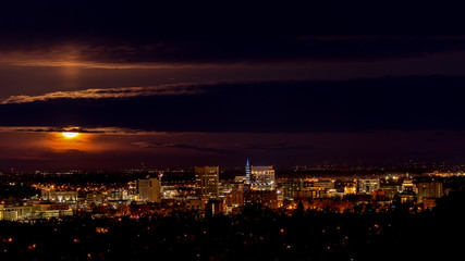 Fototapeta na wymiar Skyling of Boise at night with full moon and clouds