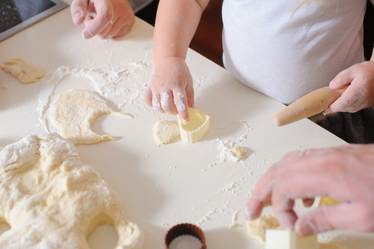 Hands adult, child cook cookies in kitchen closeup