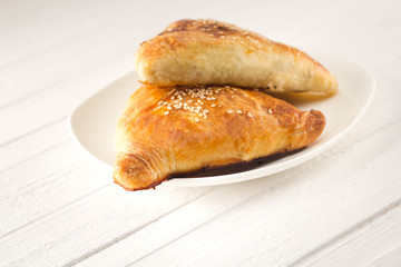 Two meat patties samsa on the white plate