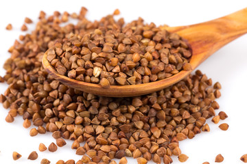 Uncooked buckwheat on wooden spoon