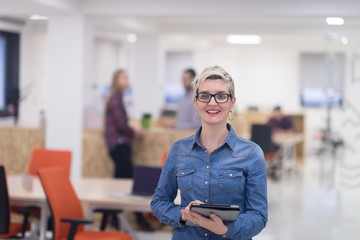 portrait of young business woman at office with team in backgrou