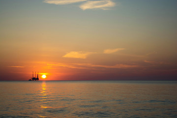 oil platform against beautiful sea sunset