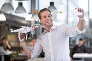 Attractive young guy is photographing with quadrocopter