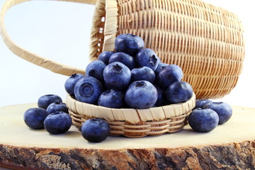blueberries in bamboo basket on white background

