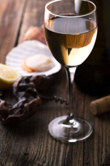 Glass of wine and scallops on a wooden