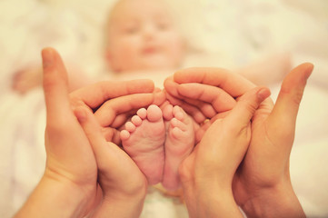 small children's feet in the hands of parents