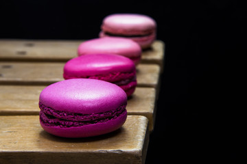 French Macaroons on wood over black
