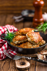 meat cutlets in frying pan on wooden rustic table