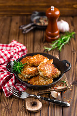 meat cutlets in frying pan on wooden rustic table