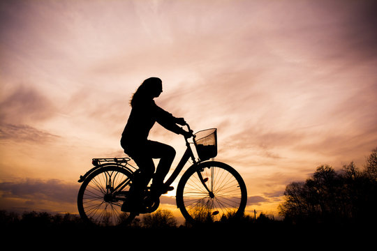Silhouette of the girl on bicycle - beautiful sunset