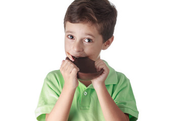 Little boy eating chocolate easter egg on white background