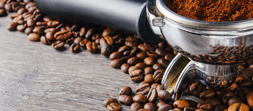 Portafilter and Coffee Beans On Wood Background