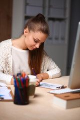 Young woman working in office, sitting at desk