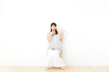 部屋で椅子に座る女性　驚く