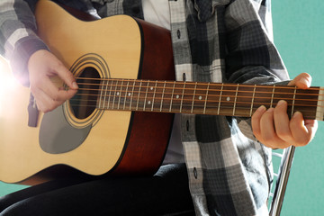 Fototapeta premium Musician plays guitar on blue background, close up