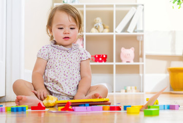 Happy toddler girl playing with her tablet computer