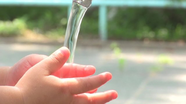 子供が水道で手を洗う様子のアップ