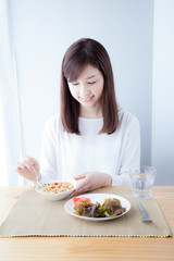 Obraz na płótnie Canvas 朝食を食べる女性　シリアル食品