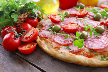 Delicious tasty pizza with ingredients on table, closeup