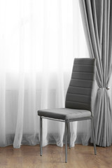 Chair in the room near the window with curtains