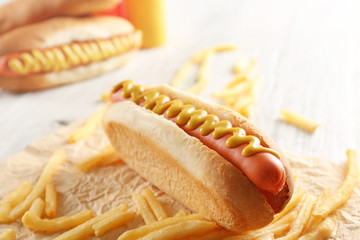Hot dogs and fried potatoes on wooden background