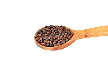 Black pepper granules in wooden spoon