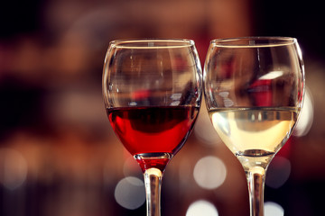 Glasses of red and white wine against blurred background