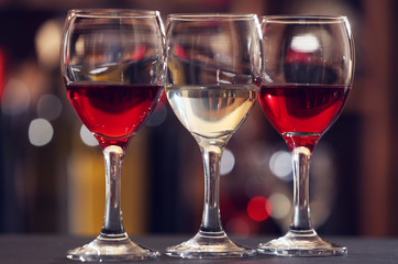 Glasses of red and white wine against blurred background