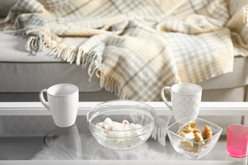Low table with sweets and two cups in living room