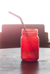 Iced drink in red glass on wooden table