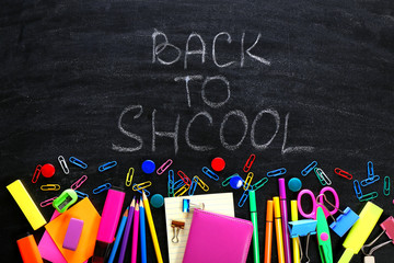 Back to school concept. Colourful stationery on black background