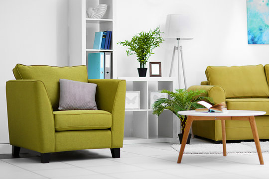 Living room interior with green furniture and table on light background