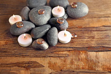Spa still life with stones and candlelight on wooden background