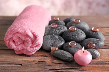 Spa still life with stones, crystals, towel and candlelight on blurred pastel background