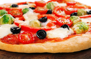 Delicious pizza with cheese and vegetables on wooden cutting board closeup