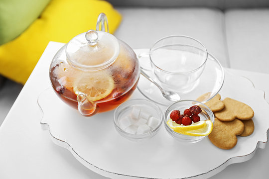 Tea set with lemon and biscuits on a white wooden mat