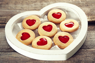 Assortment of love cookies in box on wooden background, closeup