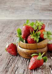Fresh strawberries in a wooden bowl, selective focus