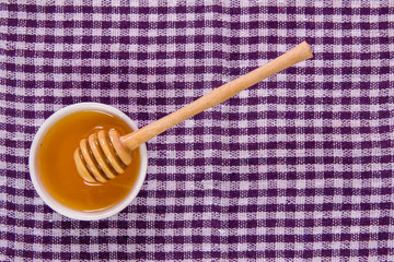 honey and spoon on the tablecloth